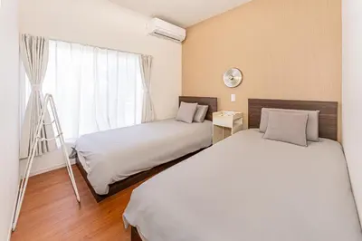 two beds in a room with a window at KAKURE Yahiro 3-Chome New 2LDK House,Washer-Dryer & Free Parking,1 Stop to Skytree in Tokyo