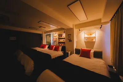 a room with three beds with red pillows at Stay Chill Toranomon in Tokyo