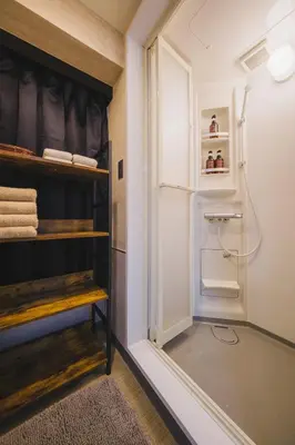 a small kitchen with a refrigerator and shelves at Stay Chill Toranomon in Tokyo