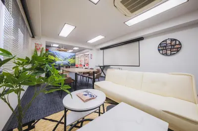 a meeting room with a white couch and tables at Stay Chill Toranomon in Tokyo