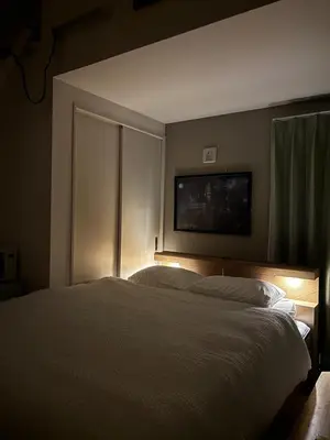 a bedroom with a bed and a tv on the wall at Pad Foot in Tokyo
