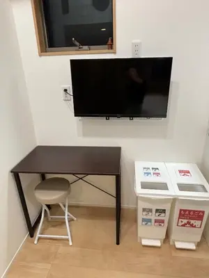 a black desk with a television on a wall at Pad Foot in Tokyo