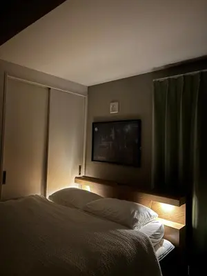 a hotel room with a bed and a flat screen tv at Pad Foot in Tokyo