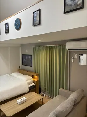 a hotel room with a bed and a clock on the wall at Pad Foot in Tokyo