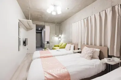 a bedroom with two beds and a couch in it at Apro Stay \u54c1\u5ddd\u685c\u30d2\u30eb\u30ba11 in Tokyo