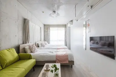 a bedroom with a bed and a green couch at Apro Stay \u54c1\u5ddd\u685c\u30d2\u30eb\u30ba11 in Tokyo
