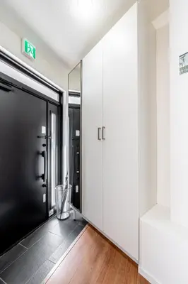 a hallway with a black door and white walls at SHOGUN HOTEL HORIKIRi in Tokyo