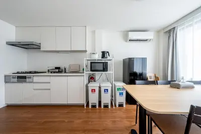 a kitchen with white cabinets and a wooden table at SHOGUN HOTEL HORIKIRi in Tokyo