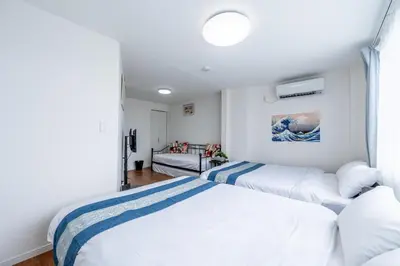 two beds in a bedroom with white walls at SHOGUN HOTEL HORIKIRi in Tokyo