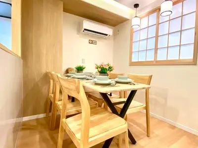 a dining room with a wooden table and chairs at H-Tokyo Simple and Warm Rooms in Tokyo