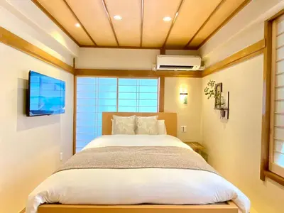 a bedroom with a bed and a large window at H-Tokyo Simple and Warm Rooms in Tokyo