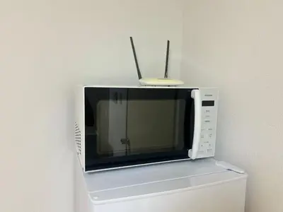 a microwave with two antennas on top of a refrigerator at XW-Ikebukuro \u4e2d\u5ddd 306-TS0040 in Tokyo