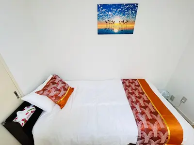 a bedroom with a white bed with colorful pillows at XW-Ikebukuro \u4e2d\u5ddd 306-TS0040 in Tokyo