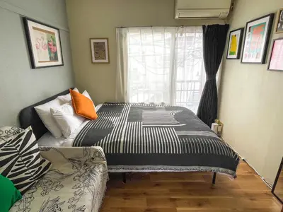 a bedroom with a bed and a couch and a window at AAt Hotel \u30a2\u30fc\u30d0\u30f3\u30cf\u30a4\u30c4\u5c0f\u83c5201 in Tokyo