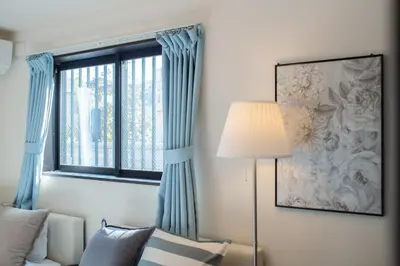 a living room with a couch and a window at Tokyo Skytree 101 Elegance Blue Twin w Bath & WC in Tokyo