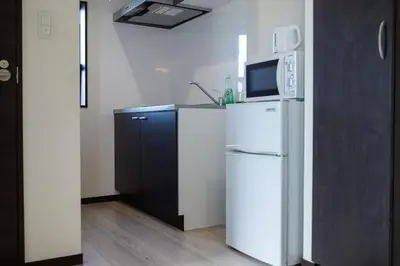 a kitchen with a white refrigerator and a microwave at Tokyo Skytree 101 Elegance Blue Twin w Bath & WC in Tokyo