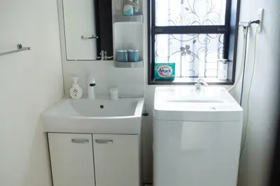 a white bathroom with a sink and a window at Tokyo Skytree 101 Elegance Blue Twin w Bath & WC in Tokyo