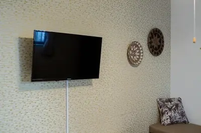 a flat screen tv hanging on a wall at Tokyo Skytree 102 Bali-Style Double bed Bath & WC in Tokyo