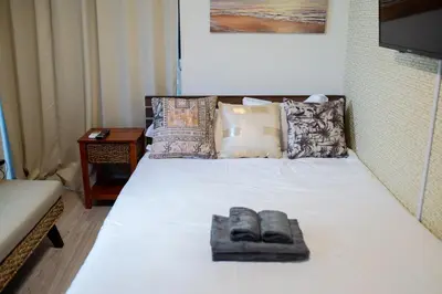 a white bed with two pairs of slippers on it at Tokyo Skytree 102 Bali-Style Double bed Bath & WC in Tokyo