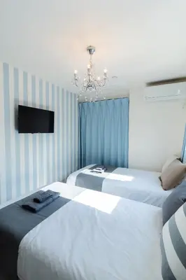 a bedroom with two beds and a tv and a chandelier at Tokyo Skytree 201 Elegance Blue Twin Room with Bath and WC in Tokyo