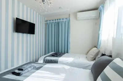 two beds in a room with a tv on the wall at Tokyo Skytree 301 Elegance Blue Twin Room bath WC in Tokyo