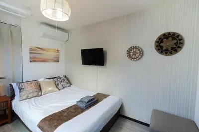 a bedroom with a bed and a tv on the wall at Tokyo Skytree 202 Bali-style Double Room Bathtub Private Bathroom 2 minutes to subway in Tokyo