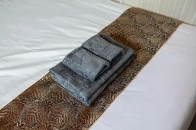 a towel sitting on the edge of a bed at Tokyo Skytree 202 Bali-style Double Room Bathtub Private Bathroom 2 minutes to subway in Tokyo
