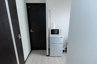 a door to a room with a microwave on a refrigerator at Tokyo Skytree 302 Bali-Style Double Bath & WC in Tokyo
