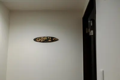 a clock on a wall next to a door at Tokyo Skytree 302 Bali-Style Double Bath & WC in Tokyo