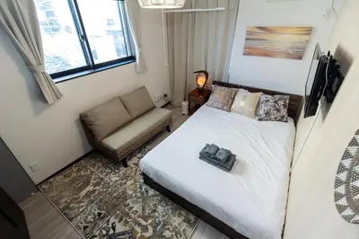 a small bedroom with a bed and a couch at Tokyo Skytree 302 Bali-Style Double Bath & WC in Tokyo