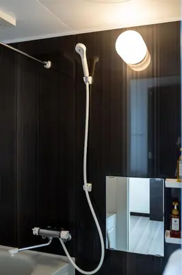 a bathroom with a shower with a light on the wall at Tokyo Skytree 401 Bali-Style Twin bed Bath & WC in Tokyo