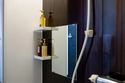 a mirror with two bottles on a wall at Tokyo Skytree 402 Bali-Style Double bed Bath & WC in Tokyo