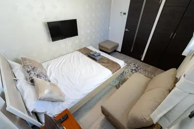a bedroom with a bed and a tv and a couch at Tokyo Skytree 402 Bali-Style Double bed Bath & WC in Tokyo