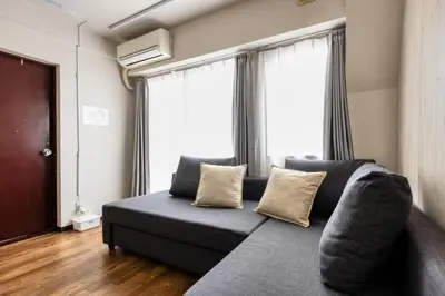 a couch in a living room with windows at Shibuya Crossing 5mins walk COZY BRIGHT COMFY PAD 35sqm in Tokyo