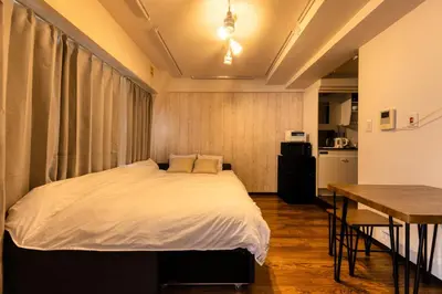 a bedroom with a bed and a table and a kitchen at Shibuya Crossing 5mins walk COZY BRIGHT COMFY PAD 35sqm in Tokyo