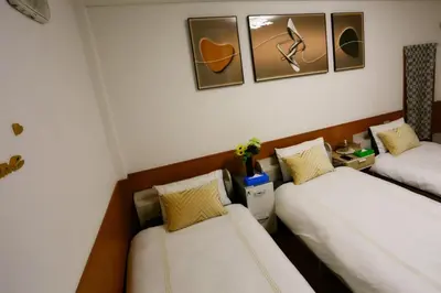 a hotel room with two beds and two pictures on the wall at \u99d2\u8fbc\u661f\u306e\u5bb6 Komagome in Tokyo