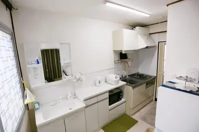 a small kitchen with white cabinets and a sink at \u99d2\u8fbc\u661f\u306e\u5bb6 Komagome in Tokyo