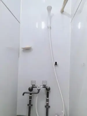 a shower in a white bathroom with a hose at \u99d2\u8fbc\u661f\u306e\u5bb6 Komagome in Tokyo