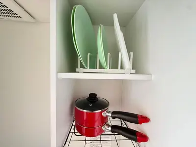 a red pot on a stove with a whisk and plates at Naomi\u4e2d\u91ce\u5742\u4e0a\u65b0\u5bbf-NN0126 in Tokyo