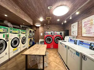 a laundry room with three washing machines and a table at D\u65b0\u5bbf\u6700\u4e2d\u5fc3 \u6b4c\u821e\u4f0e\u753a \u4e1c\u65b0\u5bbf4\u5206\u949f max3 in Tokyo