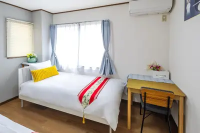 a bedroom with a bed and a desk and a window at \u82b1\u306e\u5bbf\u65c5\u9928Flower Hotel202\u5ba4JR\u7dcf\u6b66\u7ebf\u5c0f\u5ca9\u7ad9\u6b65\u884c8\u5206\u6210\u7530\u7fbd\u7530\u673a\u573a\u5df4\u58eb\u76f4\u8fbe\u8fea\u65af\u5c3c\u4e50\u56ed\u76f4\u8fbe in Tokyo