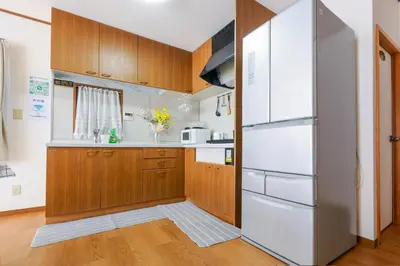 a kitchen with wooden cabinets and a refrigerator at \u82b1\u306e\u5bbf\u65c5\u9928Flower Hotel202\u5ba4JR\u7dcf\u6b66\u7ebf\u5c0f\u5ca9\u7ad9\u6b65\u884c8\u5206\u6210\u7530\u7fbd\u7530\u673a\u573a\u5df4\u58eb\u76f4\u8fbe\u8fea\u65af\u5c3c\u4e50\u56ed\u76f4\u8fbe in Tokyo
