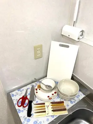 a kitchen counter with a sink with scissors and utensils at The Hope Ikebukuro in Tokyo
