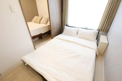 a bedroom with a bed and a mirror at Heureux\u690e\u540d\u753a301 in Tokyo