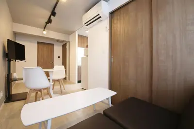a living room with a white bench and a table at Heureux\u690e\u540d\u753a301 in Tokyo