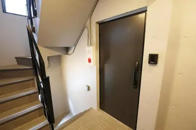a black door in a room with stairs at Heureux\u690e\u540d\u753a301 in Tokyo