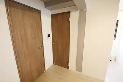a corridor with two wooden doors in a room at Heureux\u690e\u540d\u753a301 in Tokyo