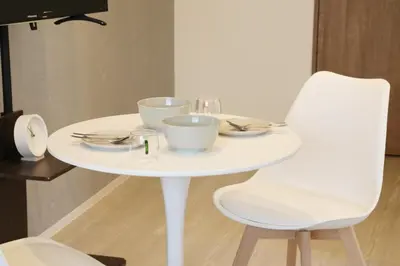 a white table with a white chair and plates and bowls at Heureux\u690e\u540d\u753a301 in Tokyo