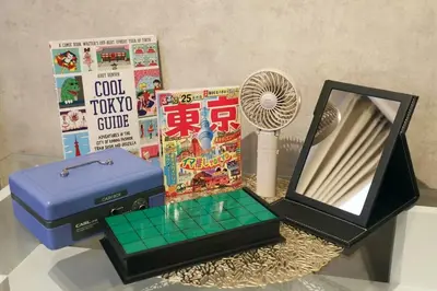a table with a fan and a box and books at \u30ac\u30a4\u30a2\u6b4c\u821e\u4f0e\u753a203 in Tokyo