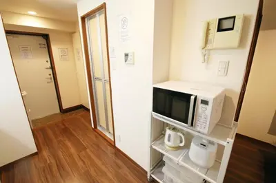 a small room with a microwave on a shelf at \u30ac\u30a4\u30a2\u6b4c\u821e\u4f0e\u753a203 in Tokyo